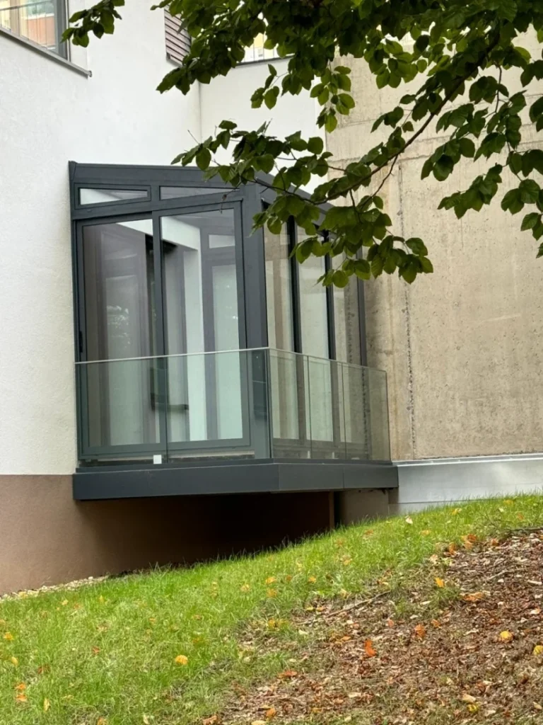 Prosklený balkon s tmavou hliníkovou konstrukcí