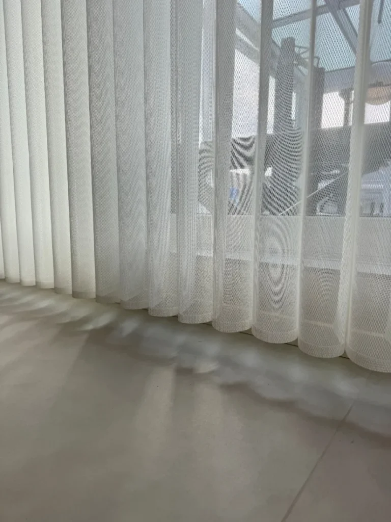 Detail světlého vertikálního stínění u okna