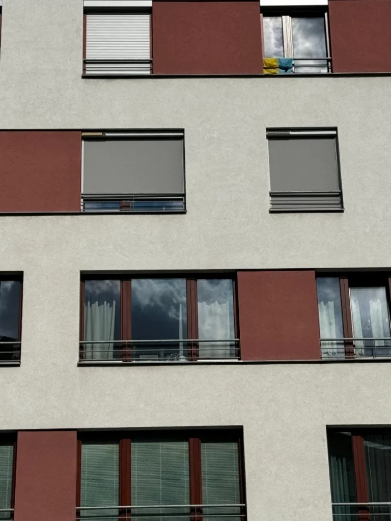Screenové rolety na oknech bytového domu