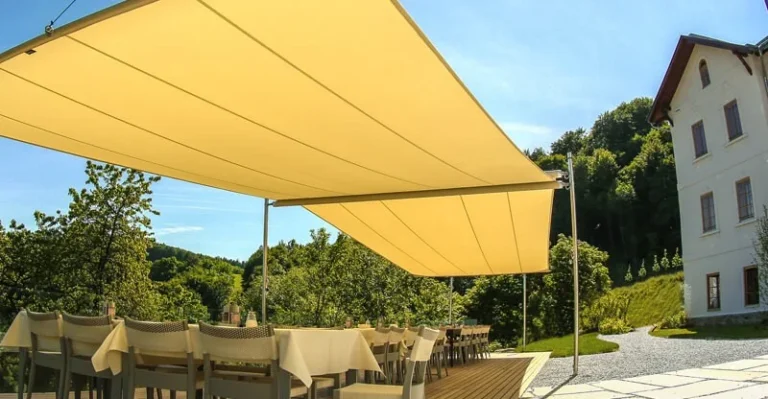 Žlutá stínicí plachta nad venkovní terasou